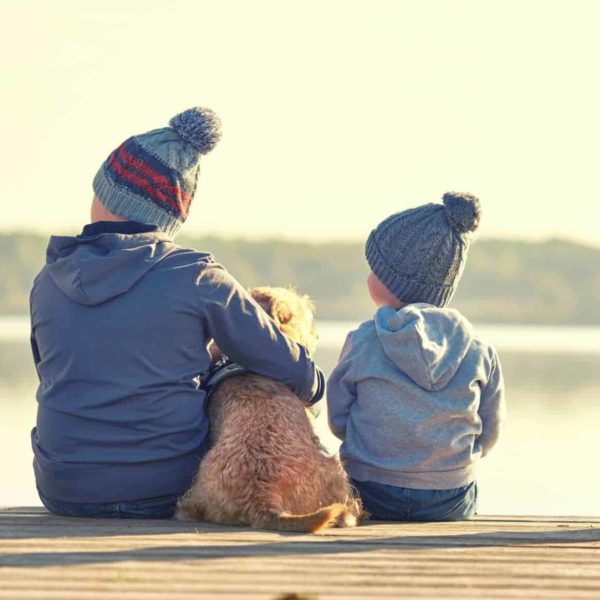 Geschisterkinder mit Hund am See