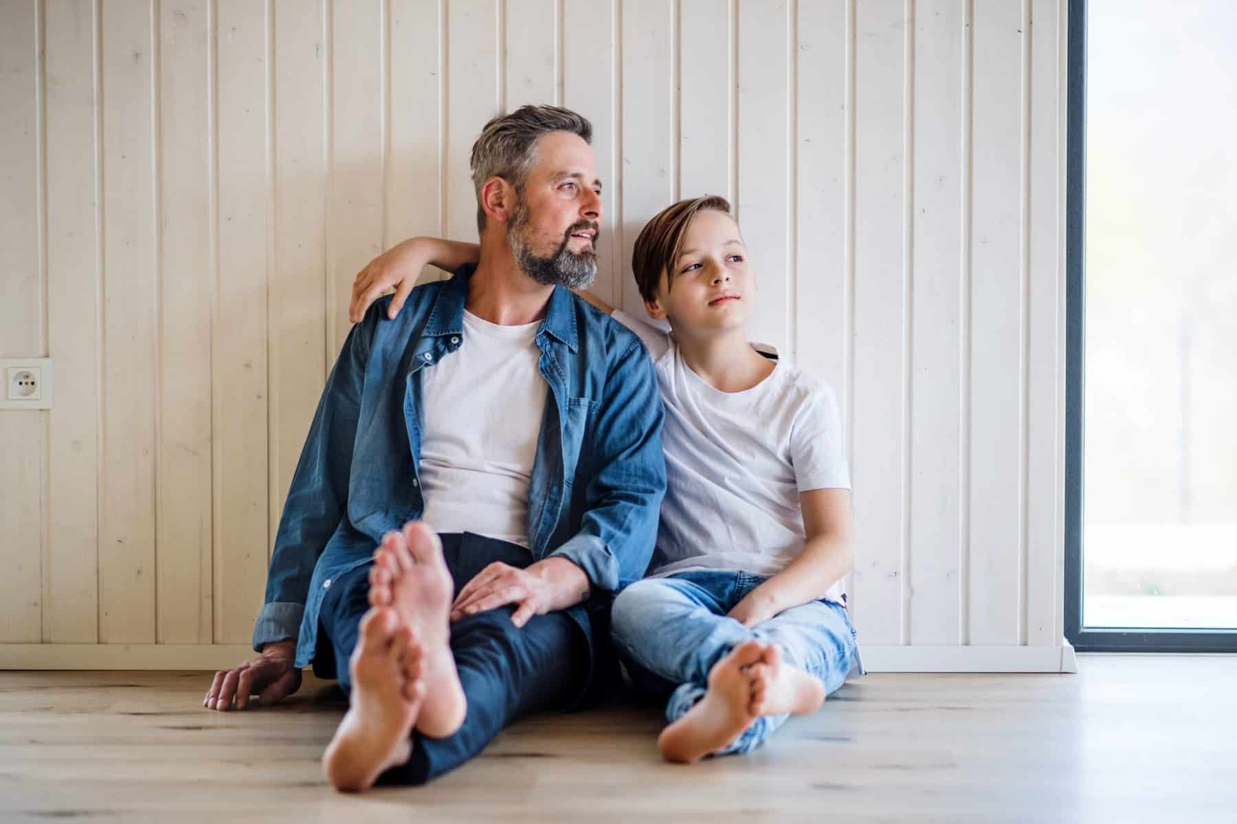 Vater und Sohn sitzen auf Boden