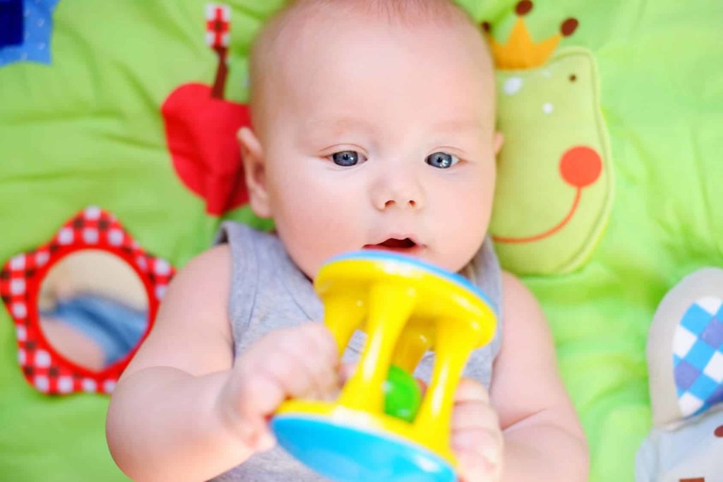 Baby macht mit einer Rassel Musik