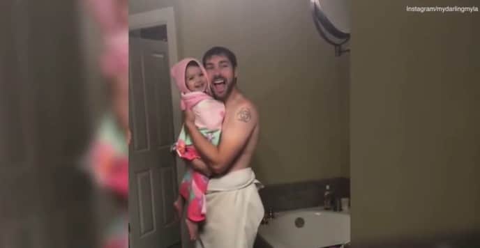 Kleine Tochter singt mit ihrem Daddy vor dem Badezimmerspiegel
