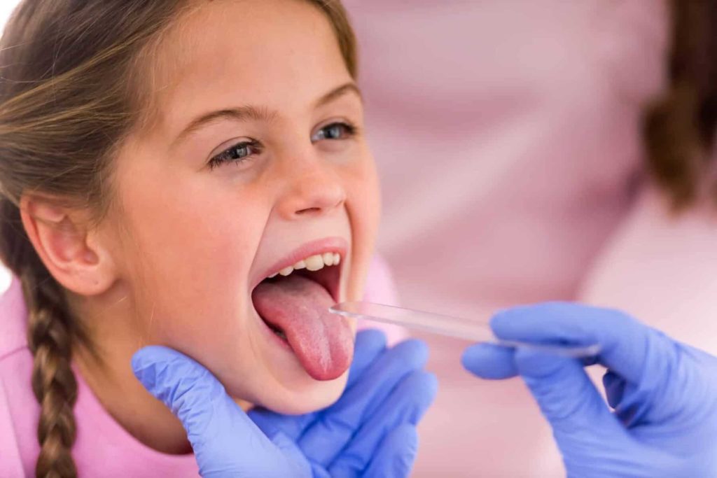 Mädchen streckt beim Kinderarzt die Zunge raus