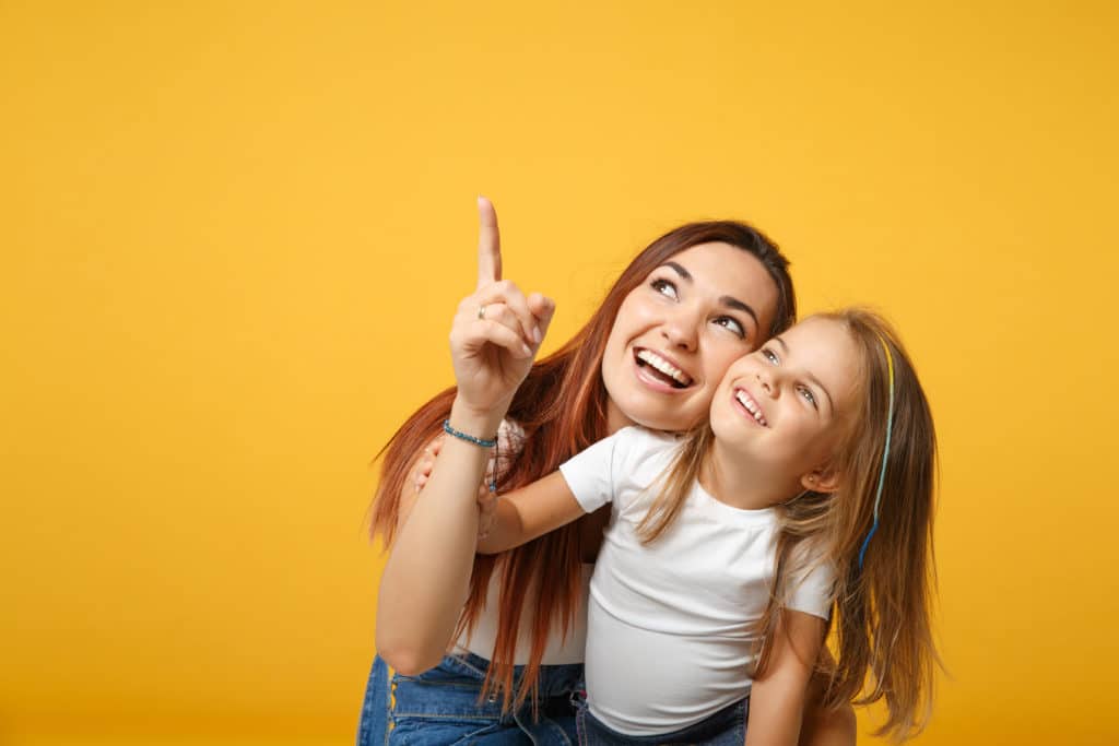 Mutter und kleine Tochter lächeln fröhlich.