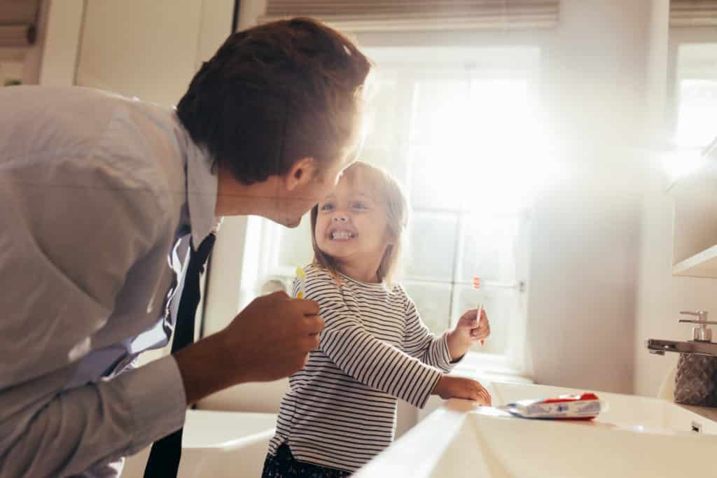 Papa und Tochter putzen die Zähne