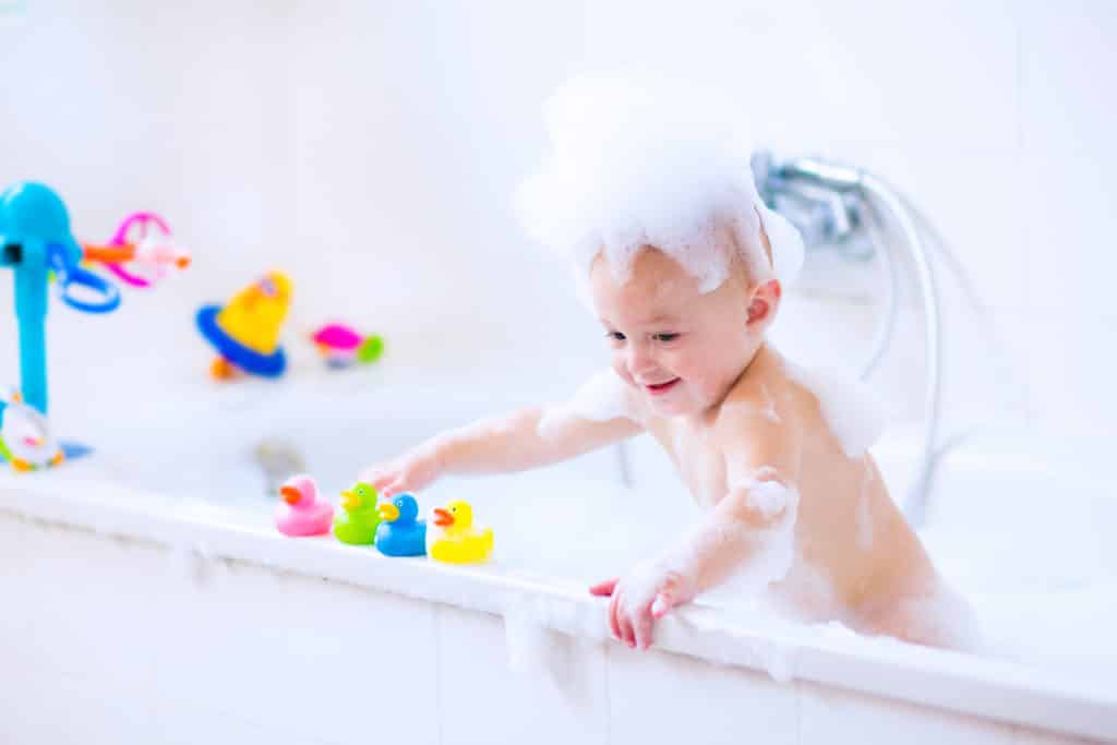 Baby mit Spielzeug im Wasser. Der perfekte Badespaß für Kinder