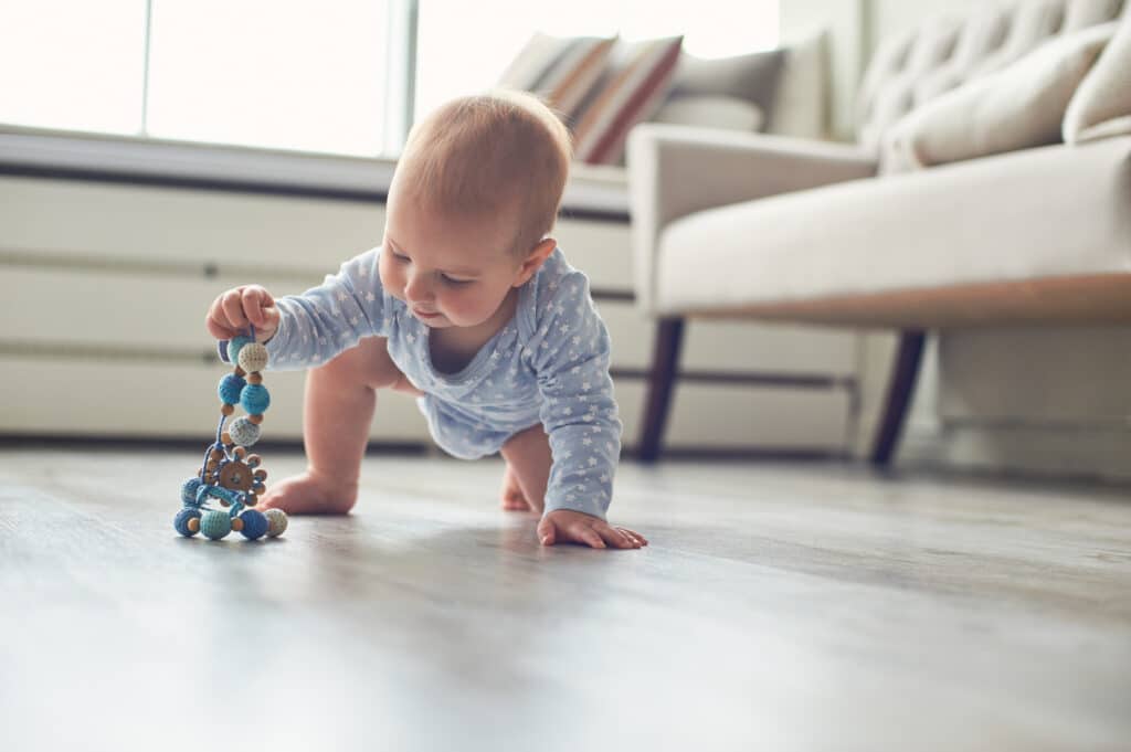 Acht Monate altes Baby spielt krabbelnd