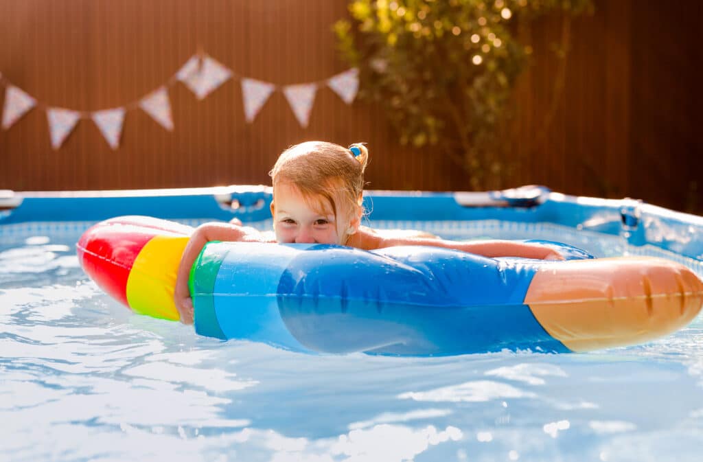 Kleines Mädchen schwimmt im Sommer im Gartenpool