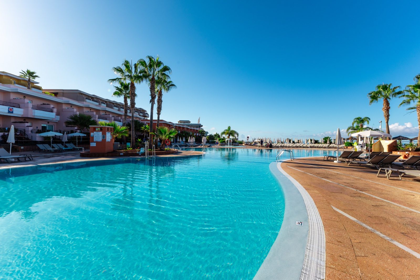 Großer Pool mit Palmen und Sonnenliegen im Landmar Costa Los Gigantes auf Teneriffa