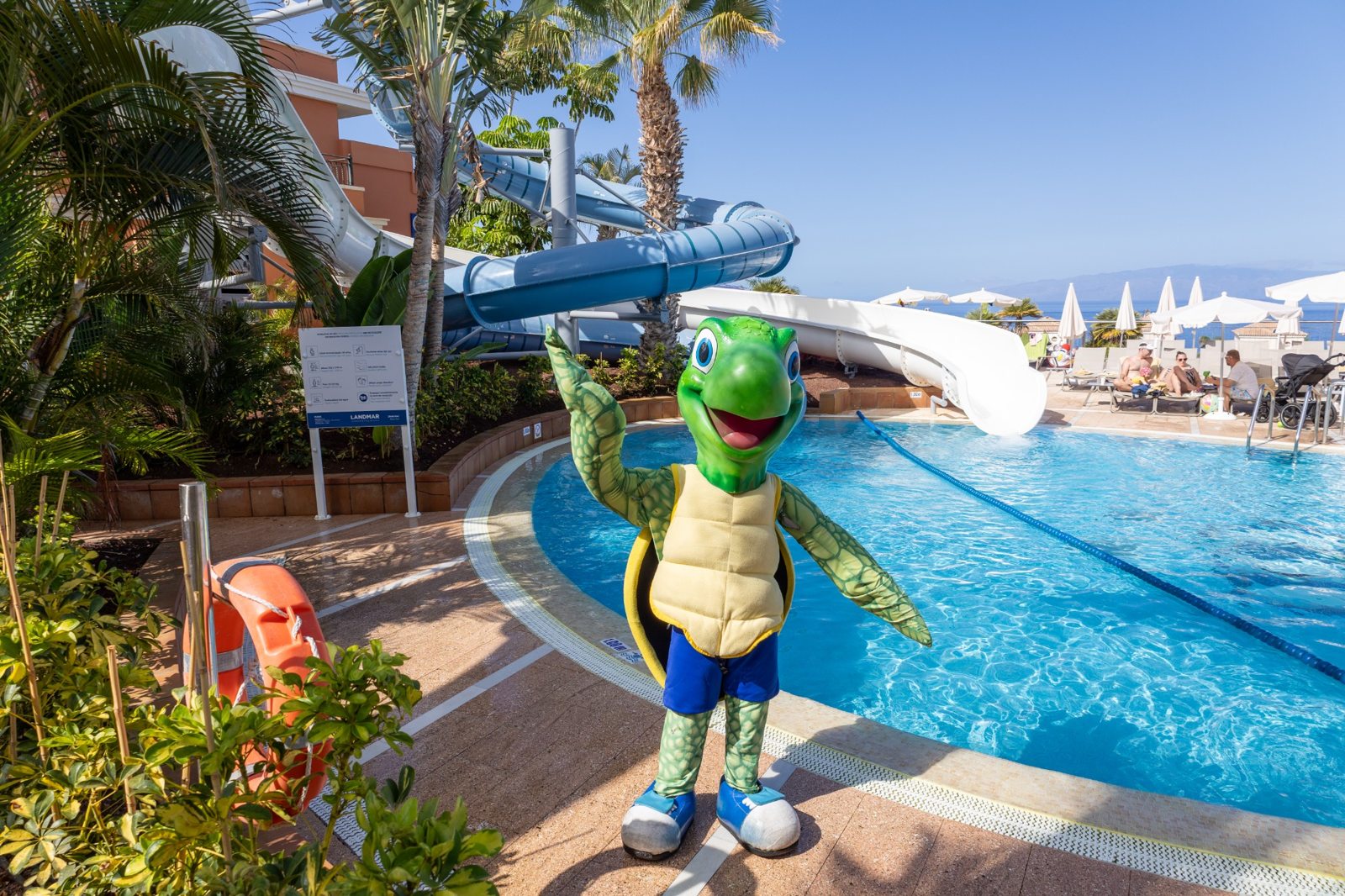 Schildkrötenmaskottchen Landi vor den Wasserrutschen am Pool des Landmar Costa Los Gigantes