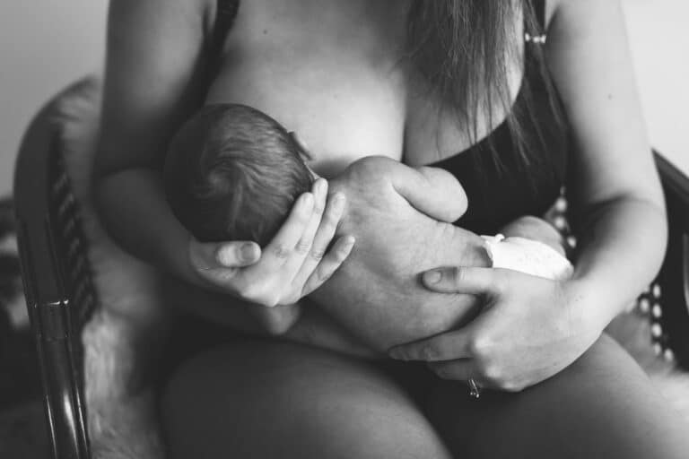 Eine Mutter hält ihr Baby im Arm und stillt es – Schwarz-Weiß-Fotografie.